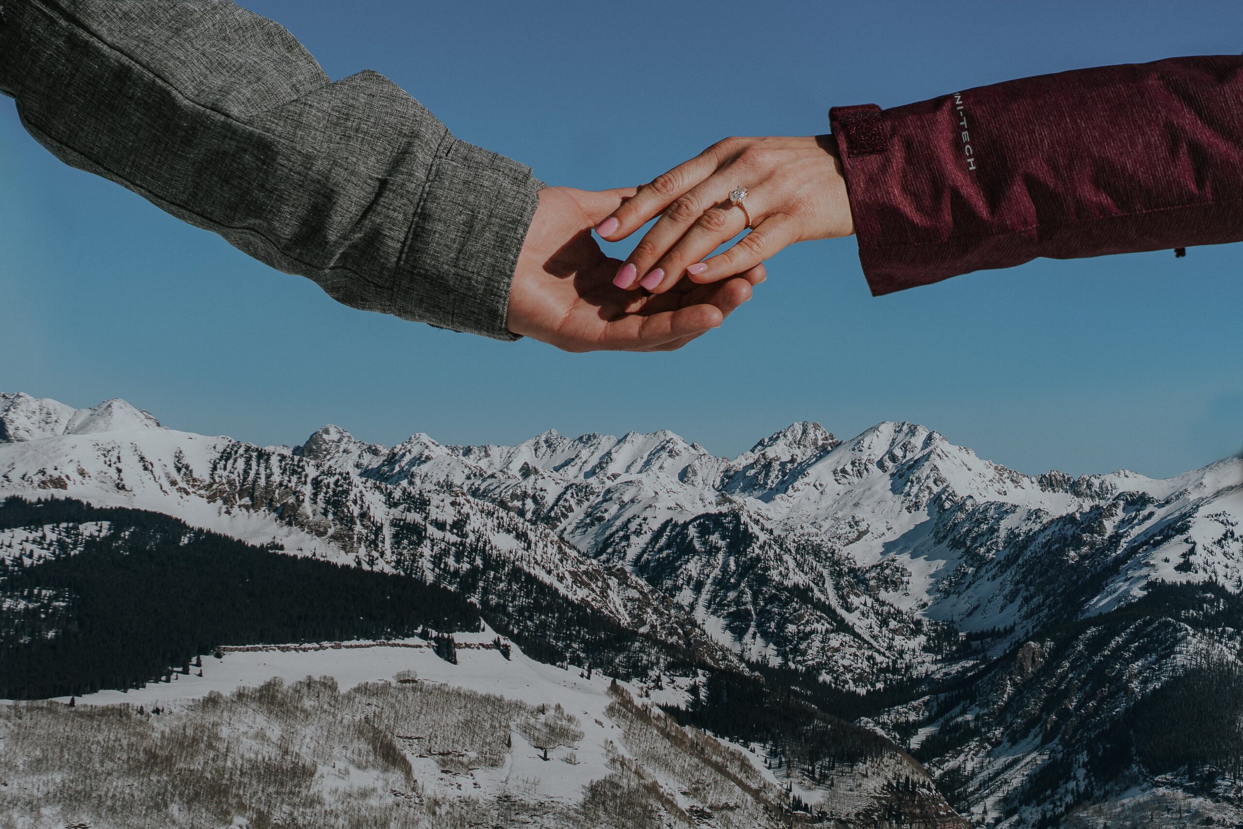 Elegant engagement ring sparkling on a backdrop of Vail Mountain's snow-capped peaks, epitomizing the romantic ambiance of a Vail engagement