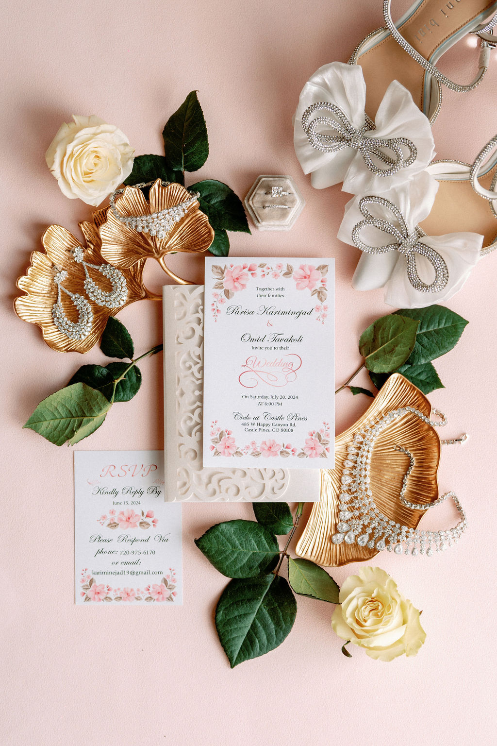 Bridal details on a pink tablecloth with shoes, jewelry and invitations