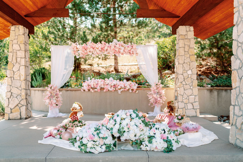 Details of a traditional ceremony set up on the ground with white and pink roses