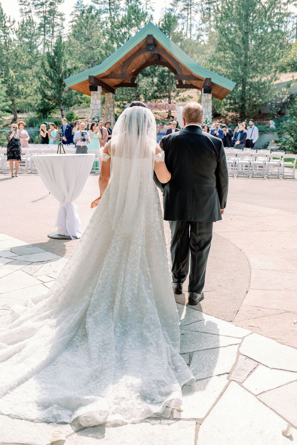 A father walks his daughter down the aisle to her Cielo At Castle Pines outdoor wedding ceremony