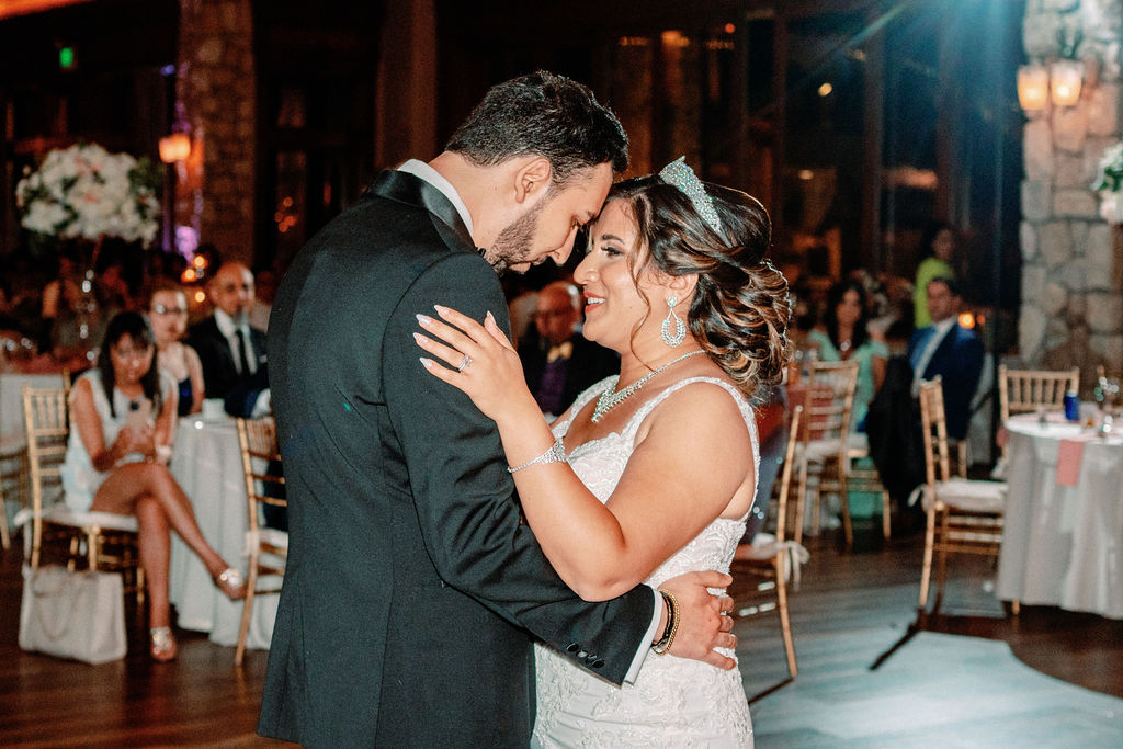 Newlyweds dance for the first time as guests look at at their Cielo At Castle Pines reception
