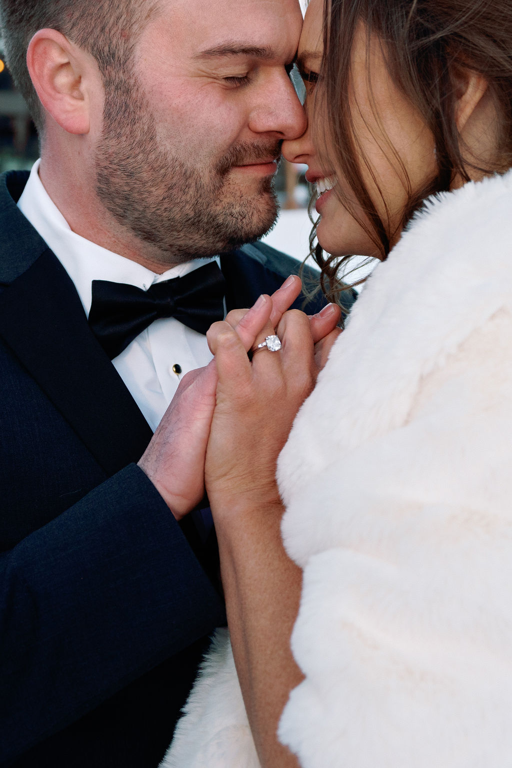 Closeup of newlyweds snuggling and holding hands