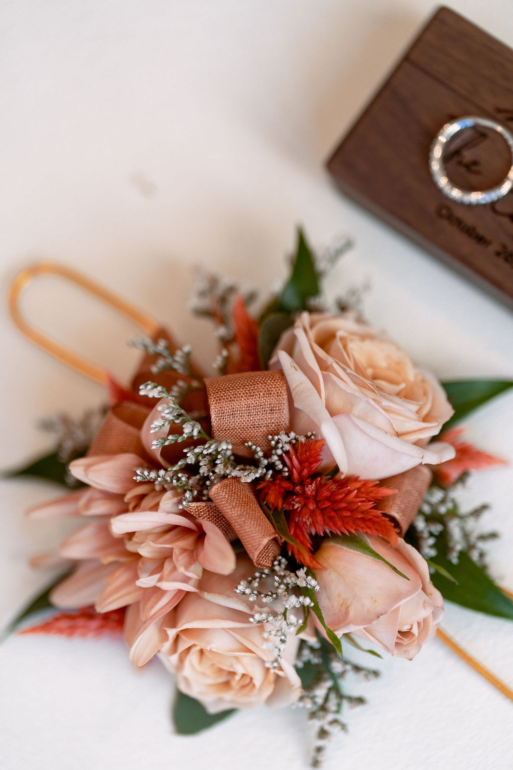 Details of pink flowers ona. table with rings and custom ring box