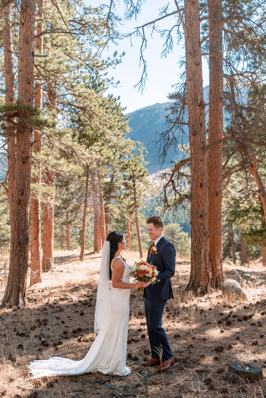 A bride and groom share a laugh in the pine forest of the Della Terra Wedding venue