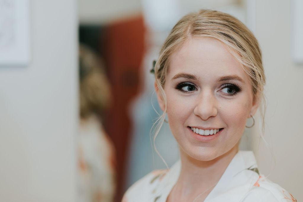 Ceoseup of a blonde bride as she gets ready in pajamas