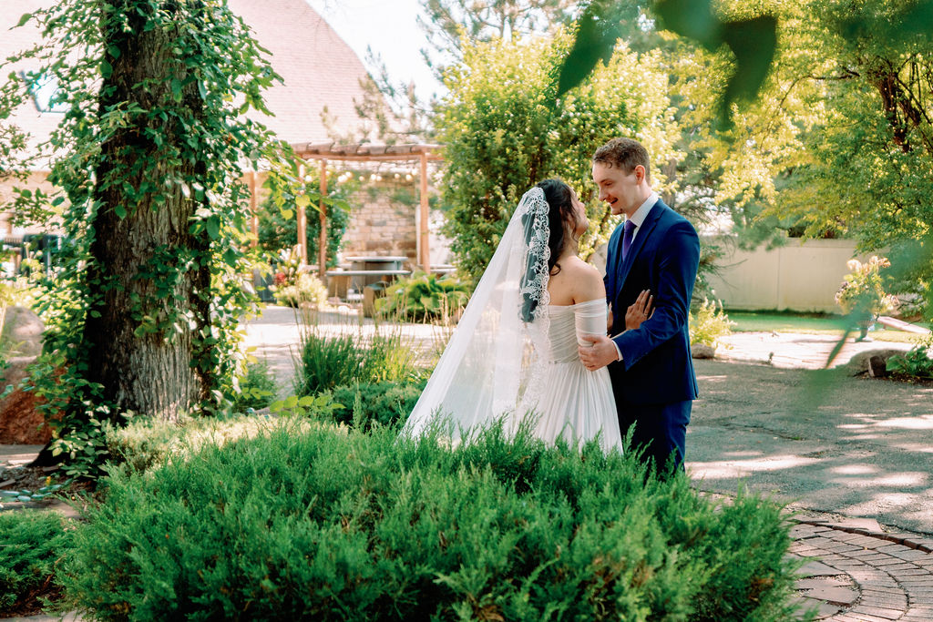 A bride and groom share a quiet moment in the gardens chatting at Tapestry House By Wedgewood Weddings