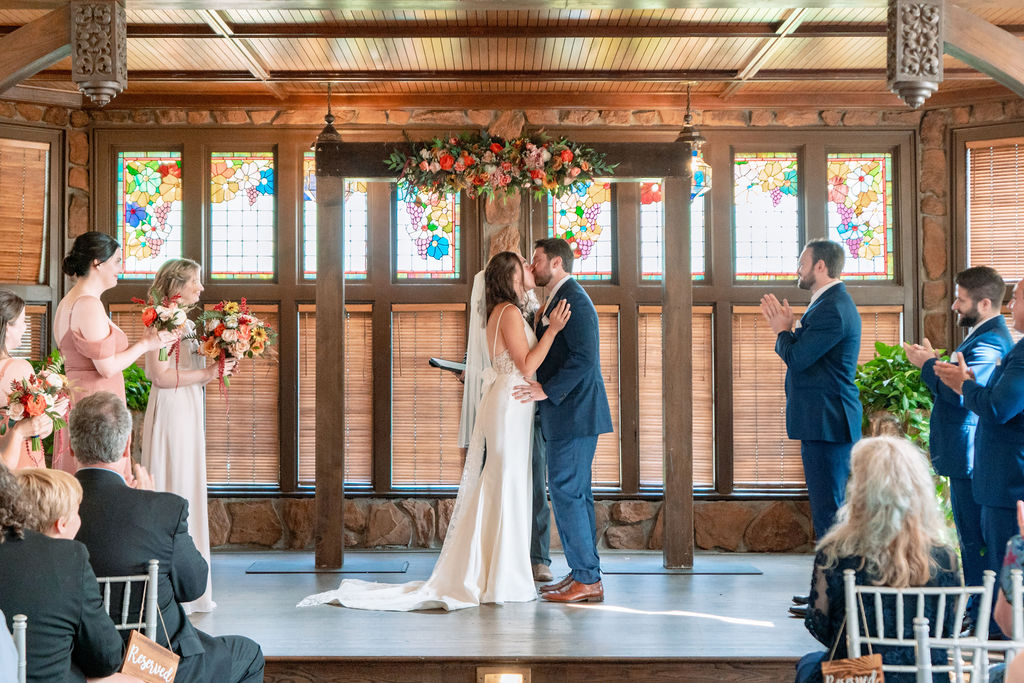Newlyweds kiss at the altar to end their Wellshire event center wedding venue near Denver ceremony