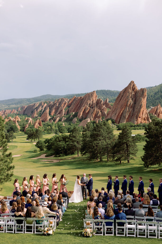 A look at an outdoor golf course wedding ceremony taking place with an epic backdrop at one of the wedding venues near Denver