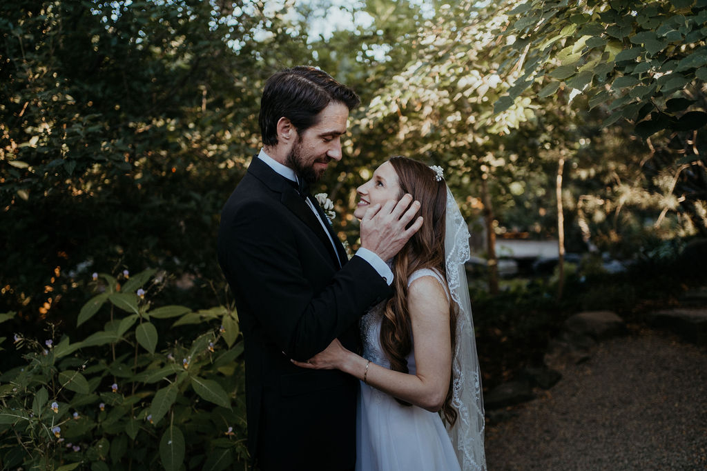 Newlyweds share a snuggle and smile in the Denver Botanic Gardens