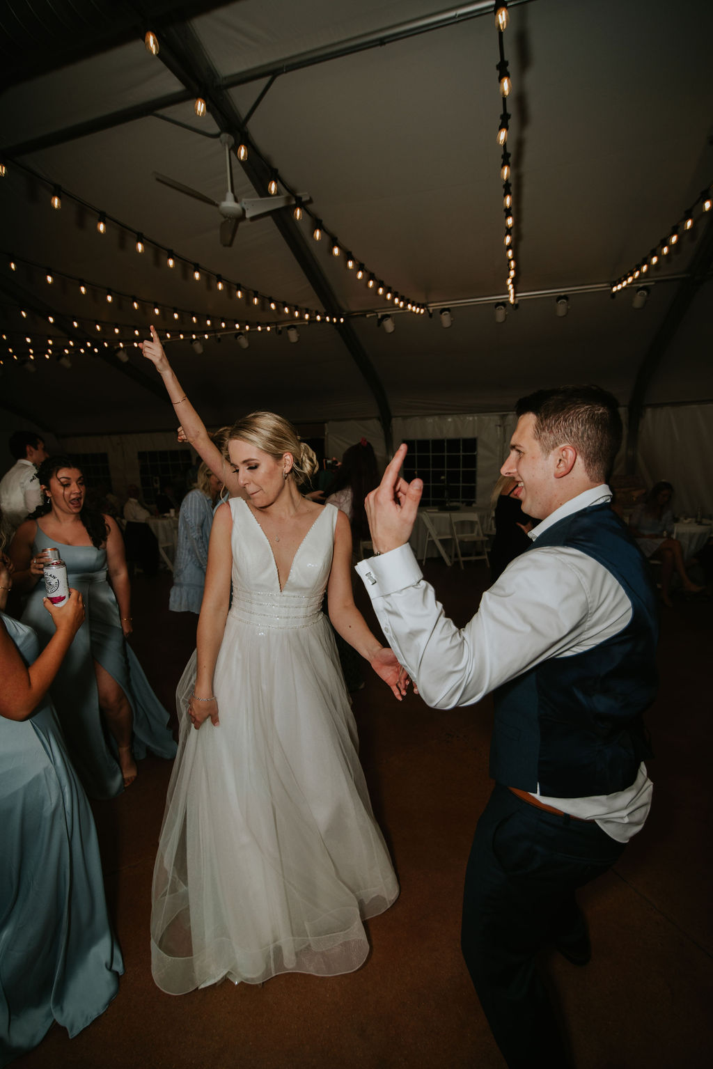 A bride and groom dance surrounded by bridesmaids on the dance floor at their reception